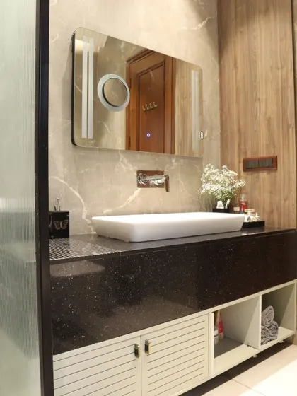This master bathroom features a sleek PU vanity with a black granite top, stone-look wall tiles, and a modern LED mirror.
