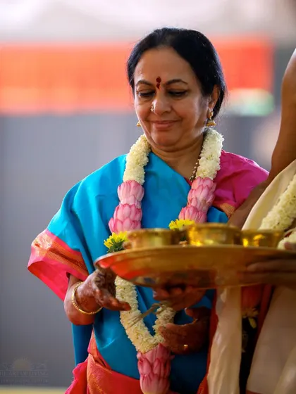 A woman offers a tray of sacred items during a puja, her expression one of serene devotion. The aesthetic and cultural richness of these rituals are a feast for the soul.