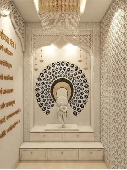 This grand pooja room showcases exceptional craftsmanship with floor-to-ceiling intricate jali work and marble carvings. A stunning peacock feather mandala creates a divine backdrop for the Krishna idol, while a crystal chandelier adds a layer of opulence.