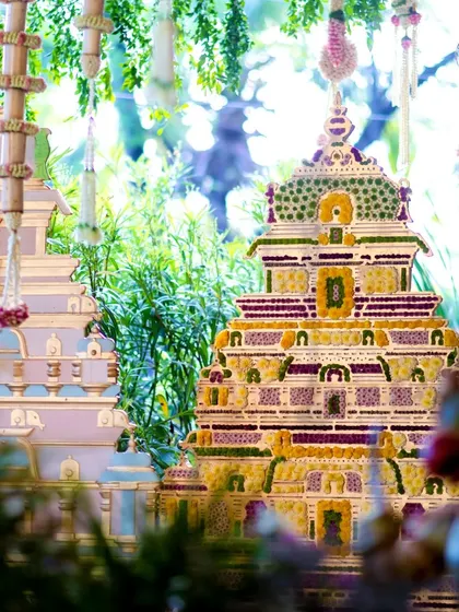Intricately crafted floral gopurams, inspired by South Indian temple architecture, created a stunning focal point for this intimate engagement ceremony. It's a celebration of love wrapped in heritage and beauty.