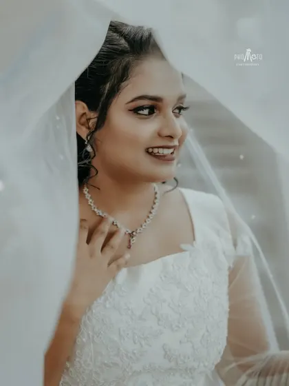 A delicate and intimate portrait of the bride, her face partially obscured by her veil, creating a soft and dreamy look.