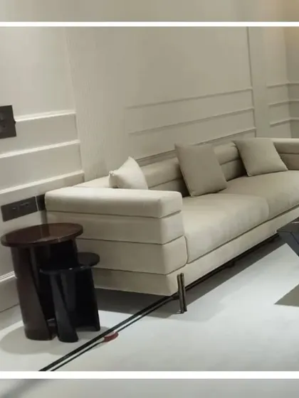This modern, low-profile sofa features a unique tiered armrest design. We crafted this piece for a contemporary space that required furniture with strong architectural lines and a sophisticated presence.