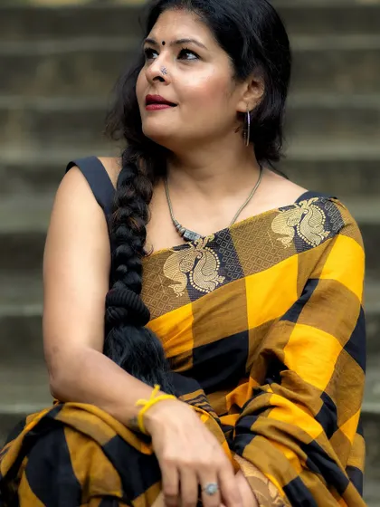 A close-up focusing on the intricate peacock motif on the border of the Kanchi cotton saree. I believe in paying attention to the fine details of every garment.