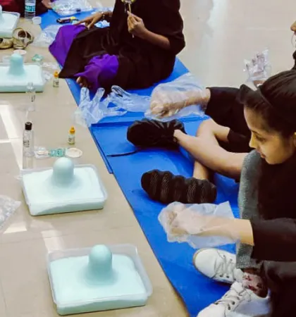 A row of young scientists ready to start their volcano experiment. Each has their own station with a tray to contain the messy fun.