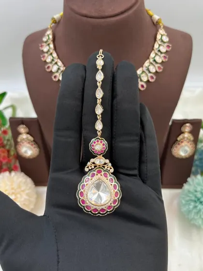 The earrings and maang tikka from our Amaya Premium Moissanite Kundan set. Notice the delicate Meenakari border and the large central stone.