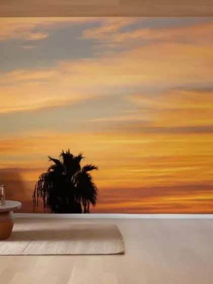 This sunset mural with silhouetted palm trees creates a warm and serene atmosphere. The beautiful orange and yellow tones are perfect for a space designed for relaxation and comfort.