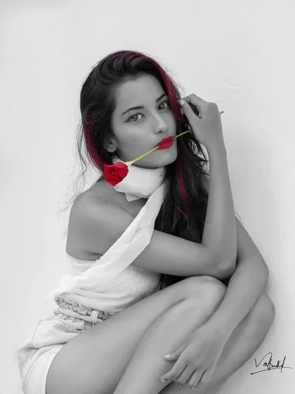 An artistic portrait using a selective color technique. By keeping the image monochrome except for the red rose, lips, and hair, I created a bold and romantic statement.