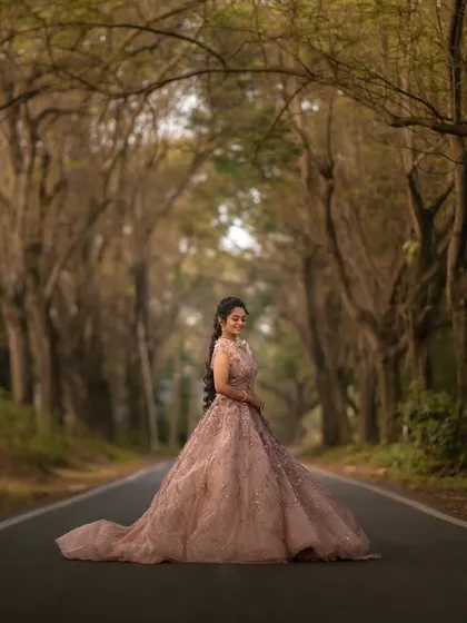 A fairytale-like portrait of the bride on a road canopied by trees. The long, flowing gown and the natural tunnel of branches create a truly magical and cinematic image.