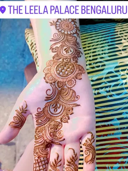Applying a delicate Arabic-style bail design for a client at The Leela Palace Bengaluru.