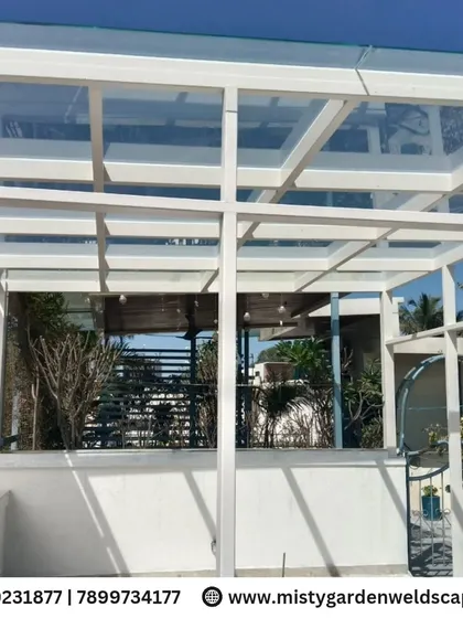 A premium 10mm toughened glass pergola at NVT Orchid Garden. The clear glass roof creates a bright and open feel while protecting the space from rain.