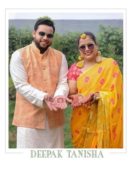 A portrait of the couple from their Haldi ceremony, showing their hands with turmeric paste.