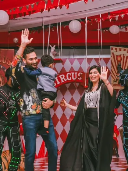 Waving goodbye to an amazing party. The family stands on stage, surrounded by performers, marking the end of a successful and joy-filled celebration.