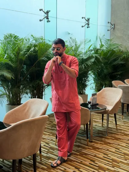 Adjusting the collar on my red kurta. It's the small details that complete a look.