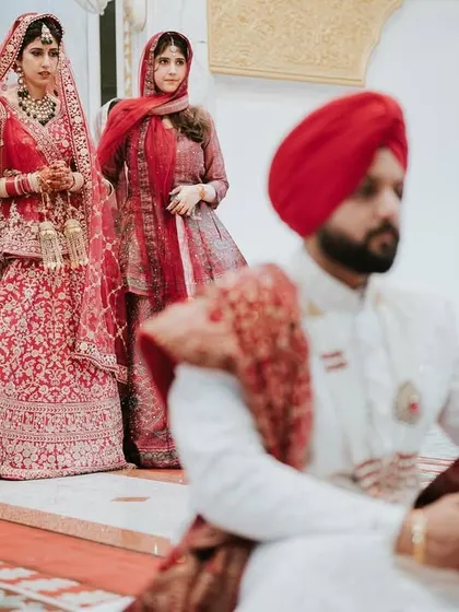 The bride's entrance during the Anand Karaj. The groom is already seated, and this shot captures the anticipation as she walks towards him.