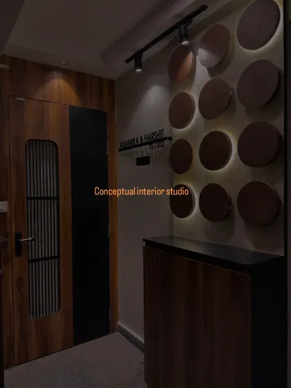 Design trends to try. This foyer features a dark wood door with a fluted glass panel, complemented by a wall with backlit circular wooden discs.
