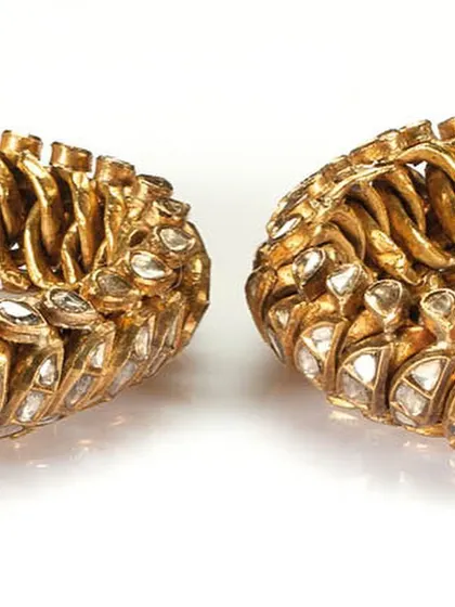 A close-up shot of the diamond polkis set in the 22-carat gold flexible bangles, highlighting the antique cut of the diamonds.