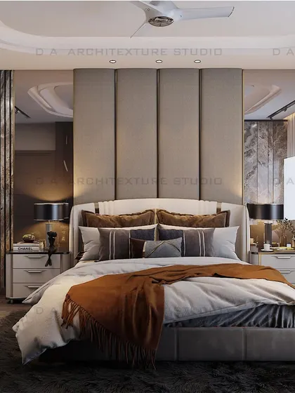 The bed-back wall in the same room, with a fabric-paneled headboard and mirrored side panels that reflect light and add a sense of depth.