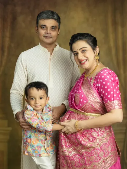 A lovely traditional family maternity photo. The older brother is so excited, gently holding his mother's baby bump.