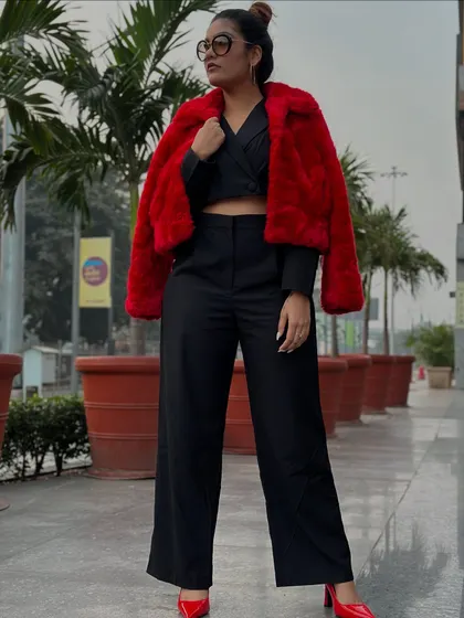 A throwback look featuring a black co-ord set with a bold red faux fur jacket and matching red heels.