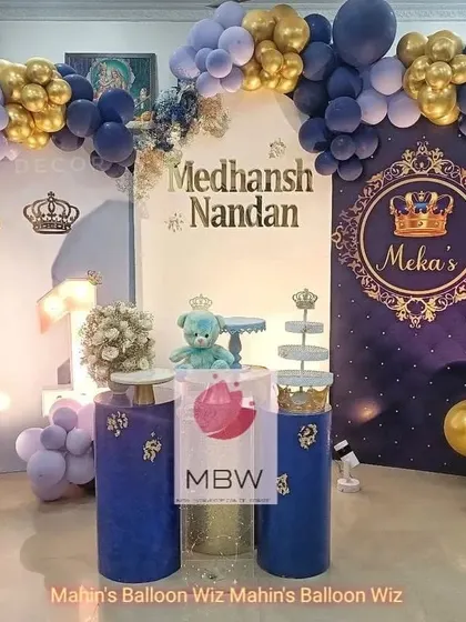 The main stage for the royal prince theme, complete with a personalized backdrop, throne-like pedestals, and a matching balloon arch.