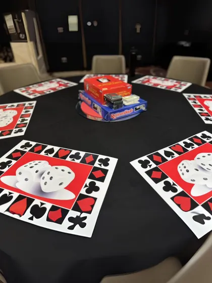 Another table setting option, this one featuring a stack of classic board games as the centerpiece for guests who prefer a different kind of friendly competition.