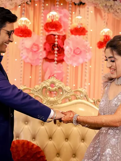 A sweet moment of connection as the newly engaged couple holds hands on stage.