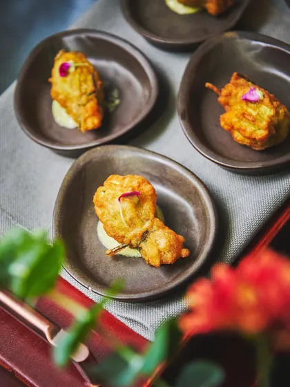 A bite-sized delight. This Fried Zucchini Blossom is stuffed with Bangalore aged cheddar, creating a crunchy, addictive, and superb canapé.