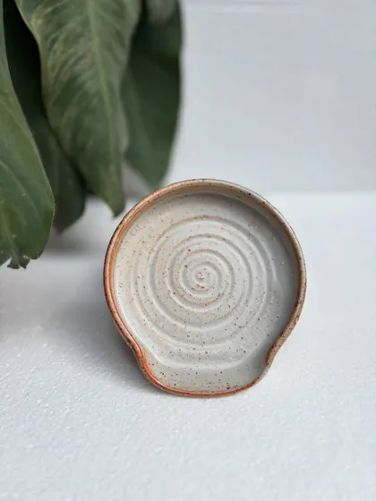 A spoon rest in our studio-made Shino glaze. The throwing rings are clearly visible, and the warm, toasty color is beautiful.