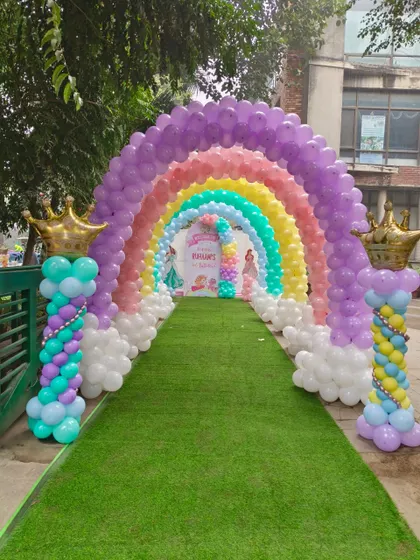 Make a grand statement with a full rainbow balloon archway. This entrance decor creates a magical pathway for guests, using a spectrum of pastel colors and cloud-like balloon clusters at the base, perfect for a princess or rainbow-themed party.