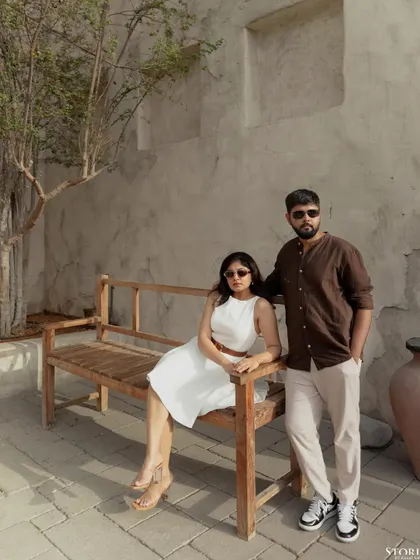A relaxed portrait on a wooden bench, capturing a quiet moment amidst the beautiful scenery of a Dubai resort.