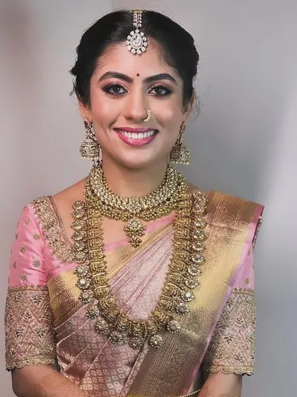 A portrait of the bride in her pink saree, highlighting the detailed craftsmanship of the blouse embroidery and the perfect fit.