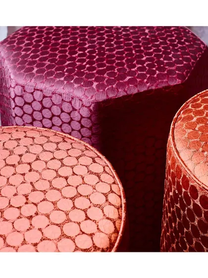 The 'BROOKS' collection has the appearance of beaten metal and inlay. These textured, geometric fabrics in rich jewel tones are perfect for adding a mix of glamour and texture to ottomans and accent chairs.
