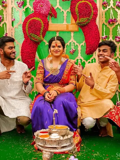 A fun moment from a pre-wedding ceremony, where the bride is surrounded by her playful brothers and friends.