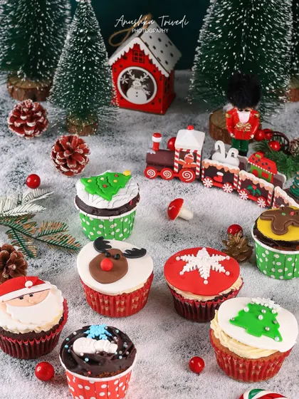 A close-up of the adorable Christmas-themed cupcakes, showcasing the detailed fondant work of Santa, reindeer, and snowflakes.