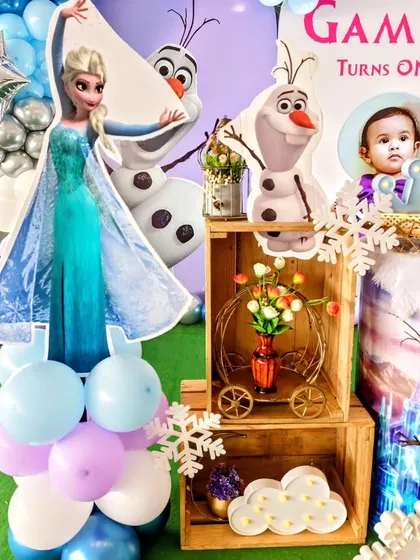 Character cutout's of Elsa and Olaf are placed amongst wooden crates and other rustic prop's for a wintery feel.