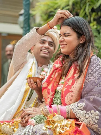 The groom lovingly applies sindoor during the ceremony, a poignant and emotional moment from their intimate wedding.