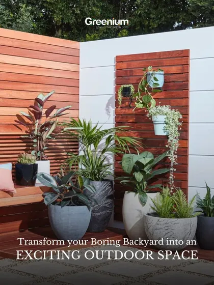 Transform your boring backyard into an exciting outdoor space. This image shows a stylish corner with a wooden bench, modern planters, and a decorative wood panel feature wall.