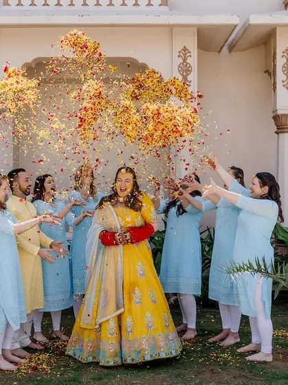 The bride and her bridesmaids enjoying a shower of flower petals during the Haldi. These are the vibrant, happy photos that perfectly capture the celebratory mood.