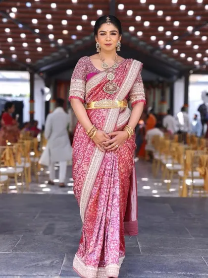 This client looks poised and elegant in her pink bandhani saree. The custom-designed blouse adds a touch of sophistication to her look.
