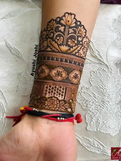 A close-up of the floral arm band from the 'tapasvi' design, highlighting the central blooming flower.