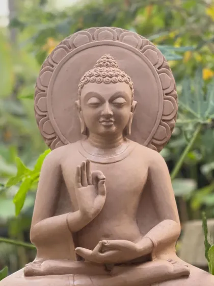 A close-up of the Gautama Buddha statue in a teaching posture. The fine details, carved from pink sandstone, capture a sense of deep calm and wisdom, ideal for any space needing a touch of serenity.