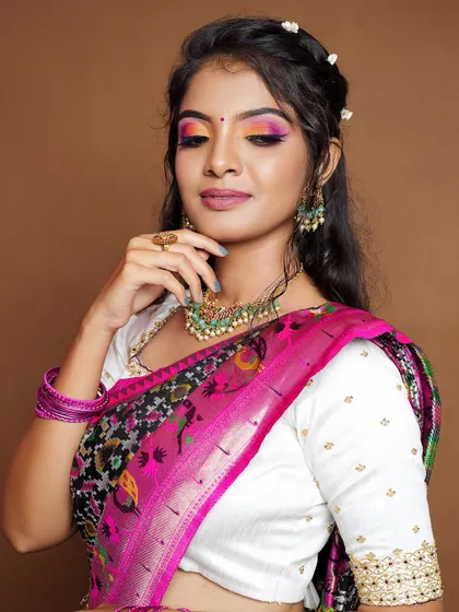 A modern twist on a traditional look, this model pairs our kundan and green bead choker with a unique saree drape.