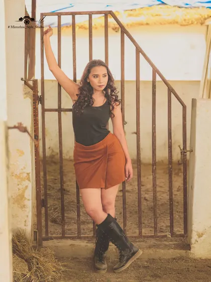 A model poses by the stable gates, capturing a "Wild West" vibe. The rustic architecture of our stables provides an authentic backdrop for themed photoshoots.