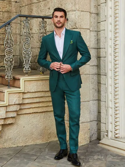A full-length view of the green linen suit. Paired with a crisp white shirt, it's a fresh and modern look for any summer event.