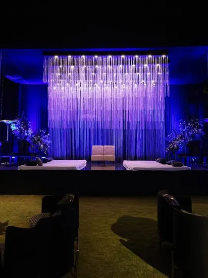 Lighting is one of my most powerful tools. This stage features a curtain of cascading crystal strings that shimmer and catch the light, creating a backdrop that is both modern and deeply romantic, perfect for a sangeet or reception.