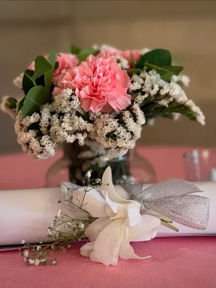 Even the smallest details are thoughtfully styled. For this Roka, each table setting included a small, fresh floral arrangement and a decorative scroll, adding a personal touch for every guest.