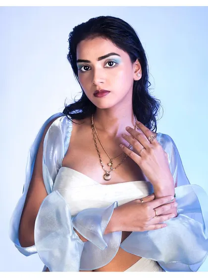 A beauty-focused shot from the same series, emphasizing the cool-toned makeup and delicate jewelry that complete the look.