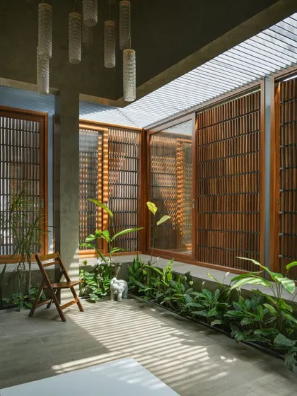 The play of light through the pergola roof of the courtyard creates shifting patterns on the floor, bringing the space to life.