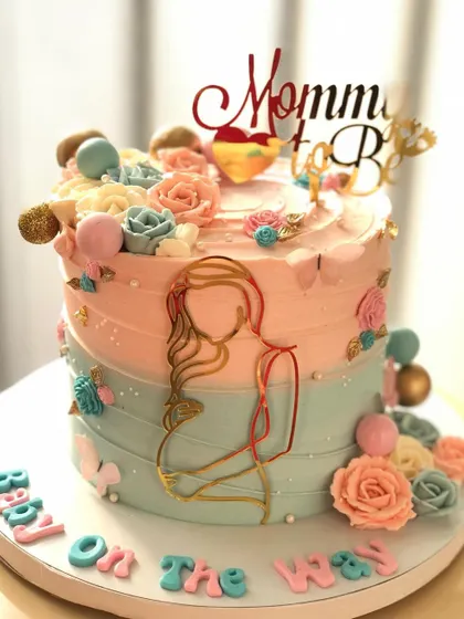 A "Baby on the Way" cake for a mommy-to-be, with a beautiful pink and blue color scheme and floral decorations.