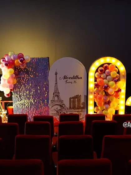 A magical Paris-themed setup inside a private theatre for a 25th birthday. The decor features a light-up Eiffel Tower, marquee numbers, and custom backdrops.